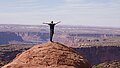 Junger Mann steht mit ausgebreiteten Armen am Rande des Grand Canyon